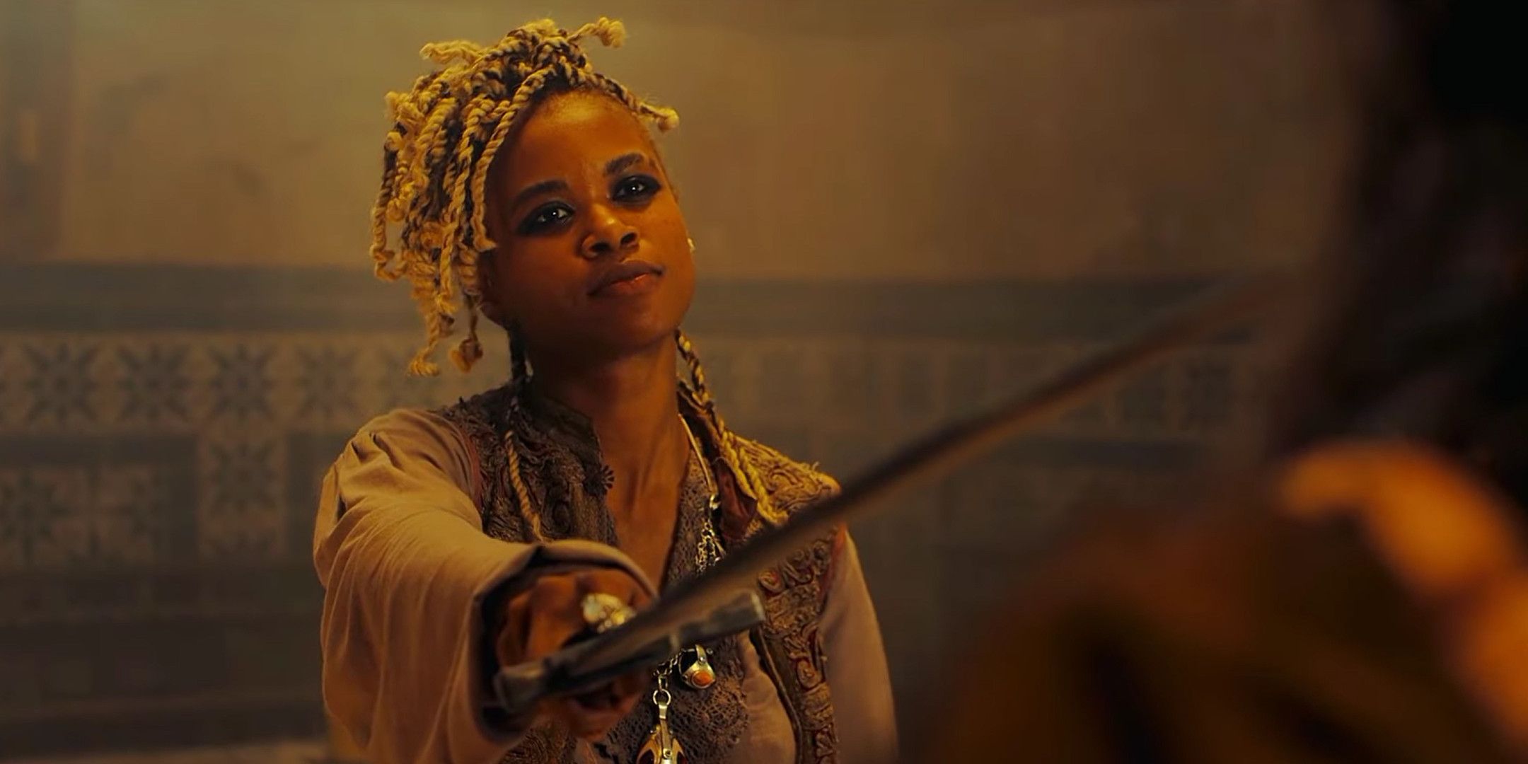 A woman pointing a sword at a man off screen